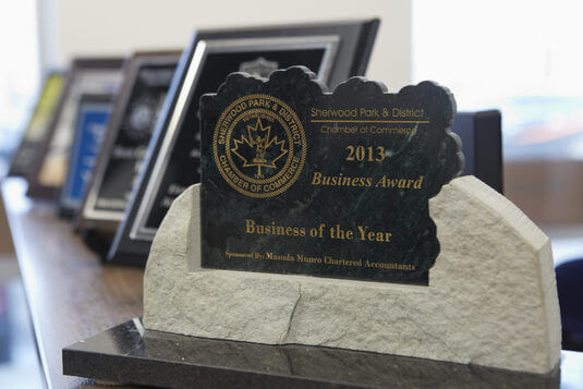 Business award displayed on a shelf with other plaques in the First Call office